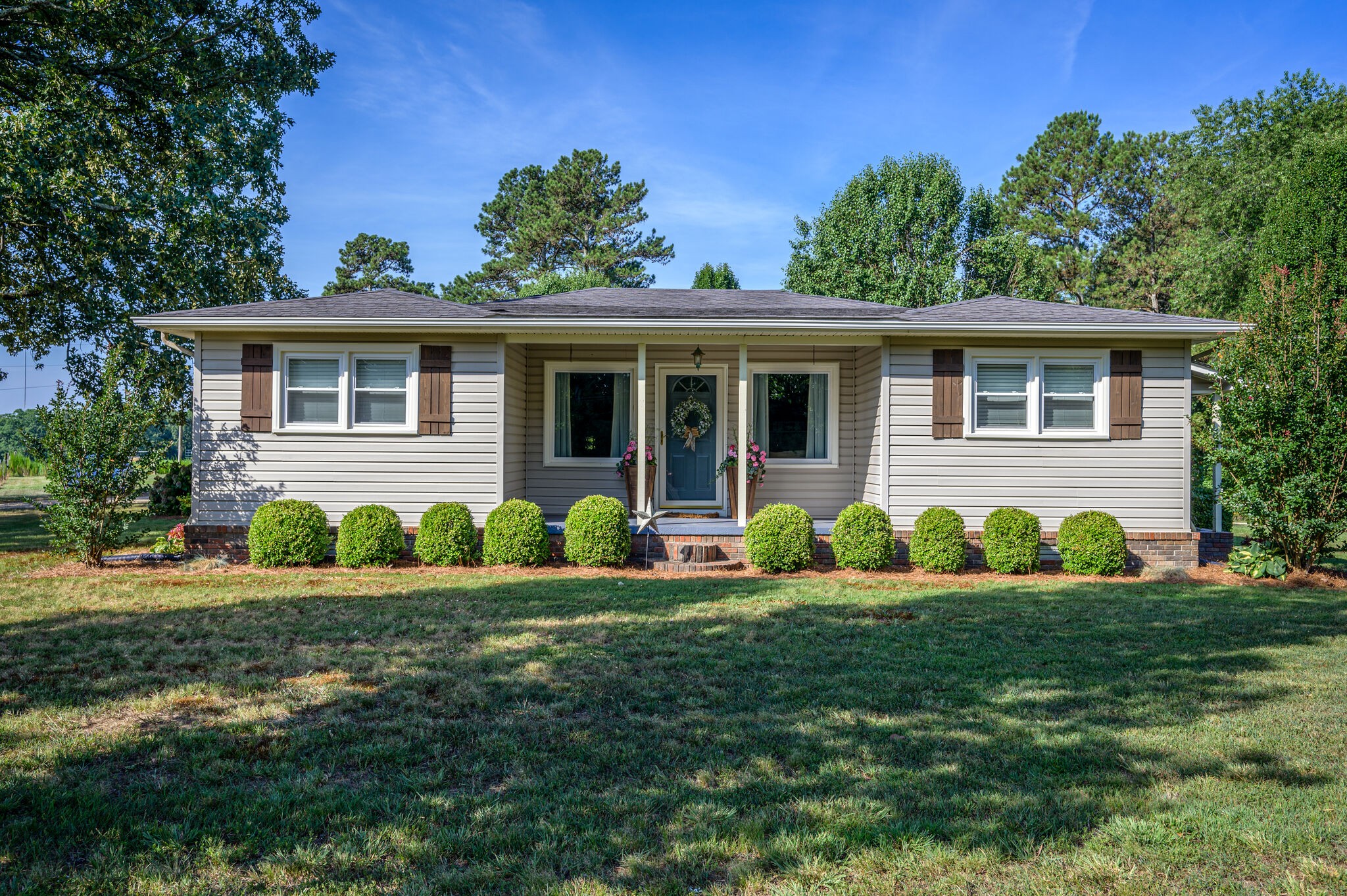 a front view of a house with a yard and green space