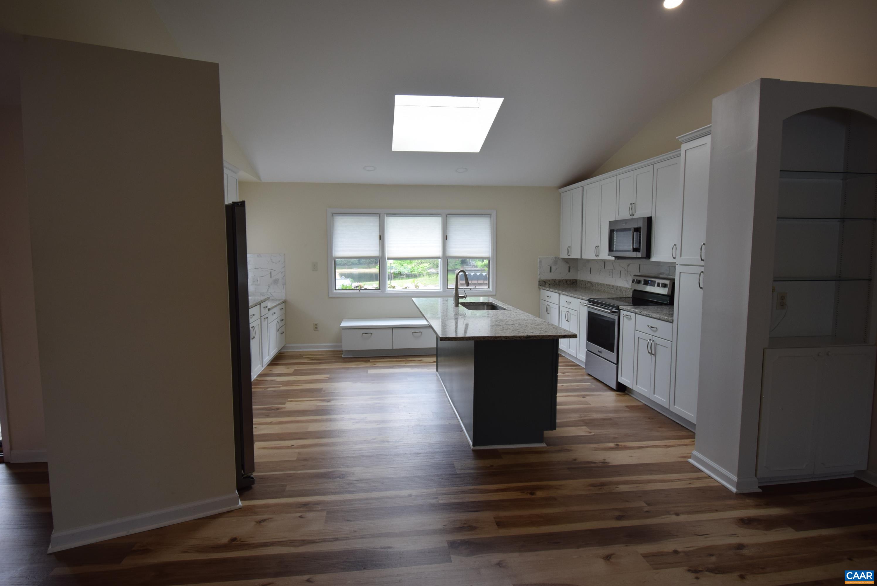 B3 Marina Point Palmyra, VA 22963 - Photo 4 of 31 a kitchen with kitchen island wooden floors and black appliances