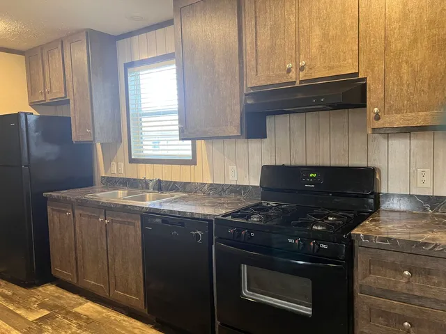 a kitchen with granite countertop a stove and a sink