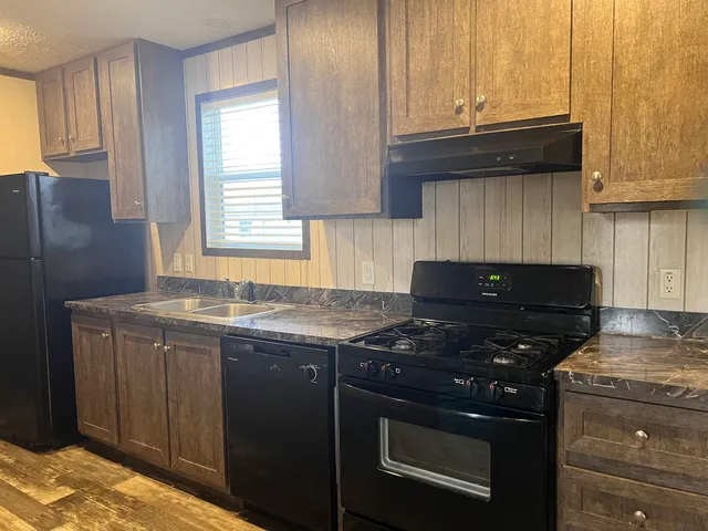 a kitchen with granite countertop a stove and a sink