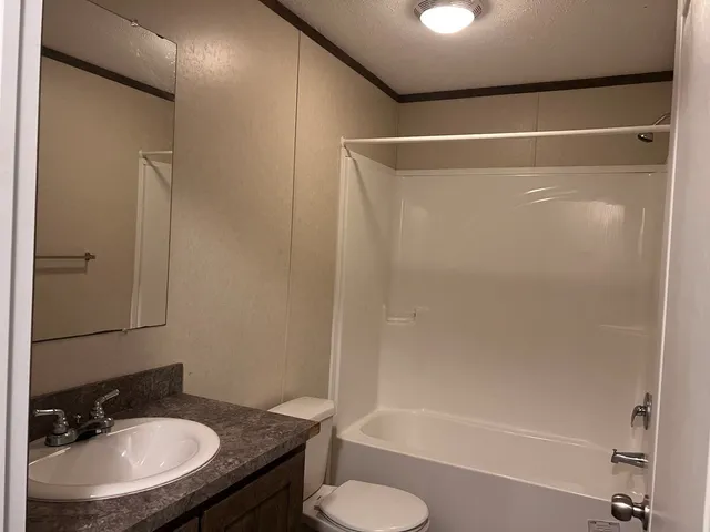 a bathroom with a sink toilet a mirror and shower