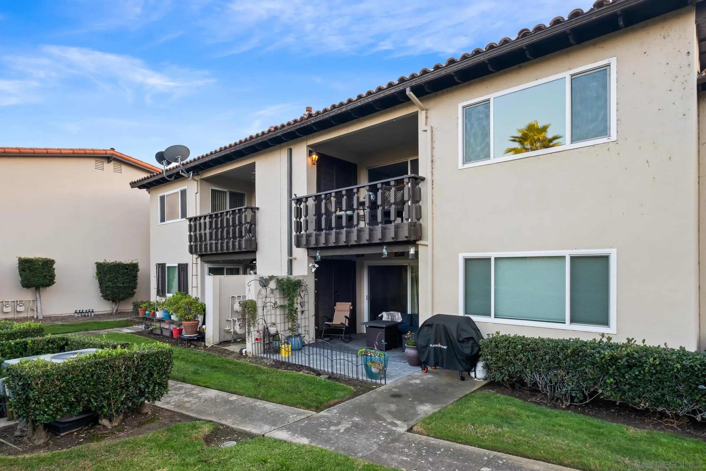 12176 Rancho Bernardo Road, Unit B San Diego, CA 92128 - Photo 24 of 41 a front view of a house with a yard and table and chairs in patio