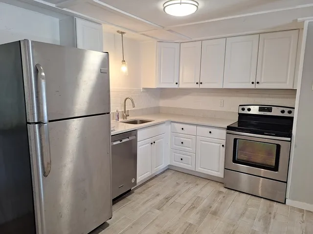 a kitchen with a refrigerator stove and white cabinets