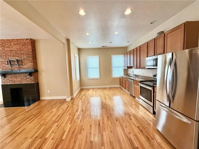 a large kitchen with stainless steel appliances granite countertop a stove and a refrigerator