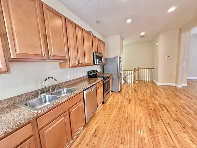 a kitchen with stainless steel appliances granite countertop wooden cabinets a sink and dishwasher