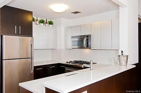a kitchen with granite countertop a refrigerator and a sink