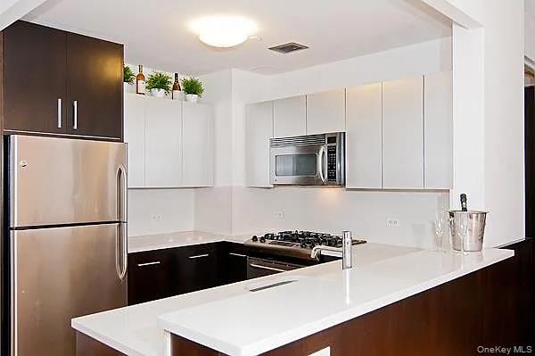 a kitchen with granite countertop a refrigerator and a sink