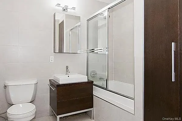 a bathroom with a sink a toilet a mirror and shower