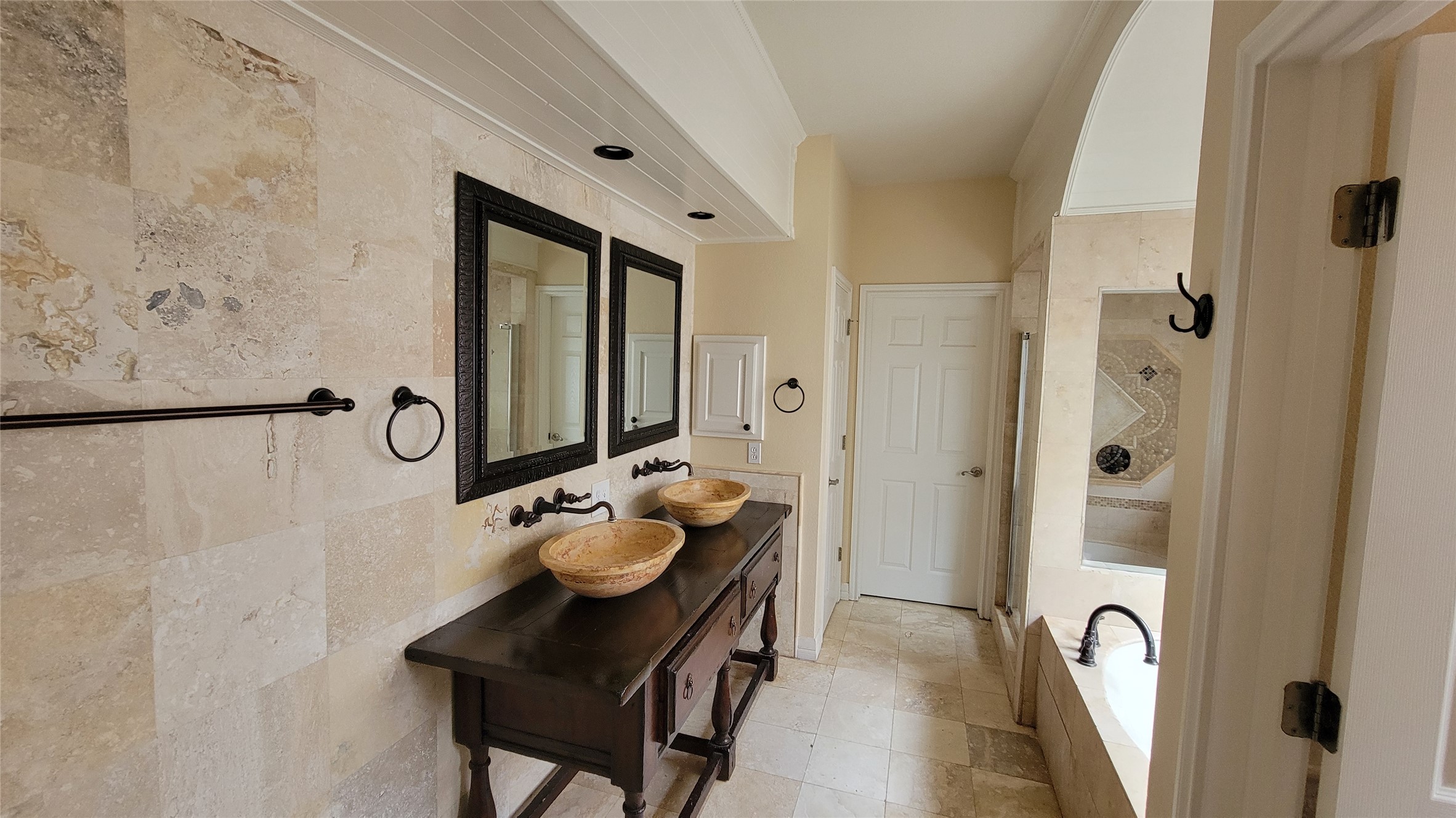 2832 Grimes Ranch Road Austin, TX 78732 - Photo 25 of 37 A well-lit primary bathroom featuring unique vessel sinks and a spacious soaking tub.