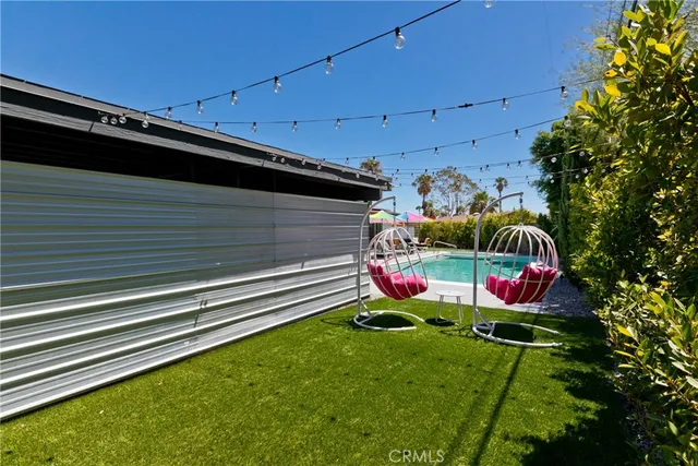 a living room with furniture kitchen view and a large window