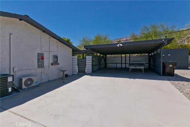 a kitchen with stainless steel appliances granite countertop a refrigerator a sink a stove and a dining table with wooden floor