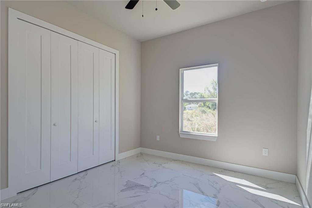 2023 Robert Avenue Alva, FL 33920 - Photo 6 of 8 Unfurnished bedroom with marble finish flooring, a closet, and ceiling fan