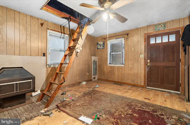 a view of a livingroom with a fireplace furniture and a ceiling fan
