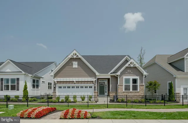 a view of a white house next to a yard with big trees