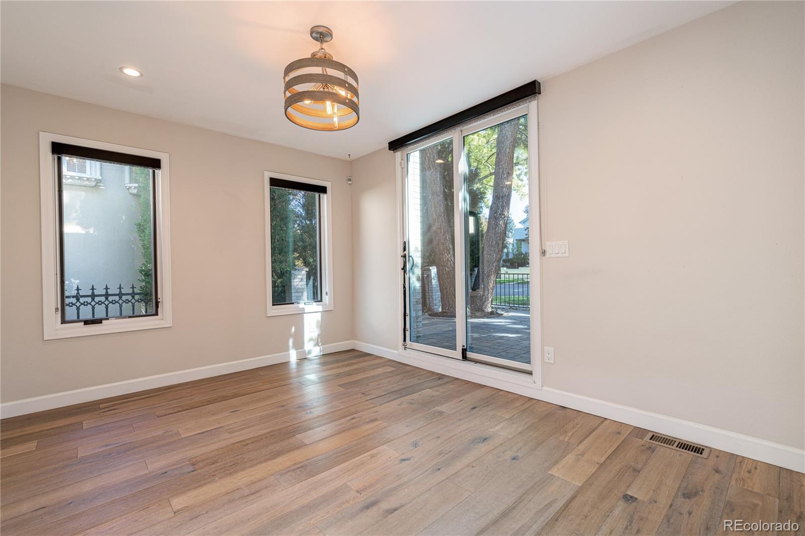 541 Monroe Street, Unit A Denver, CO 80206 - Photo 11 of 45 an empty room with wooden floor and windows