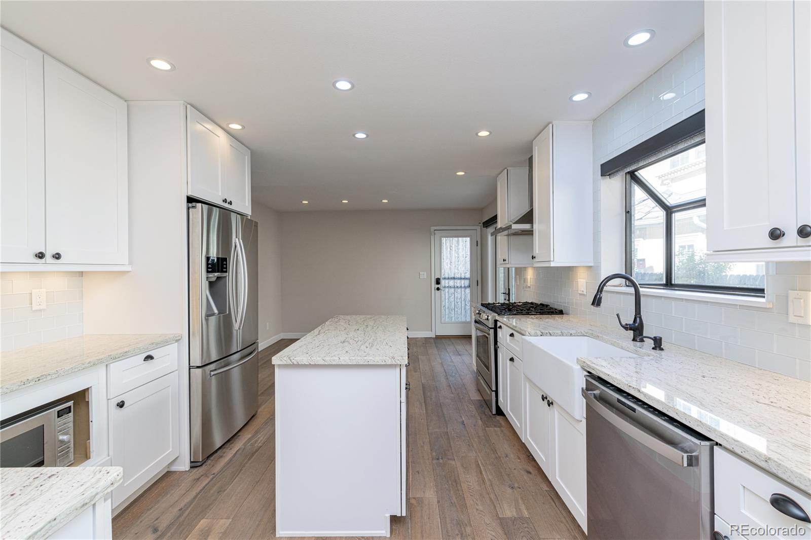 541 Monroe Street, Unit A Denver, CO 80206 - Photo 13 of 45 a kitchen with sink a refrigerator and cabinets