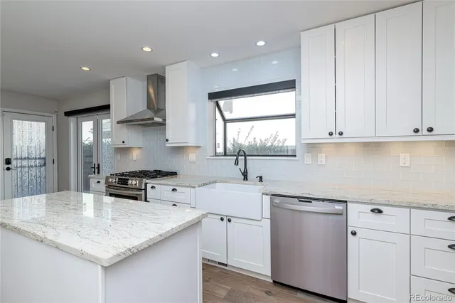 a kitchen with stainless steel appliances granite countertop a sink stove and cabinets