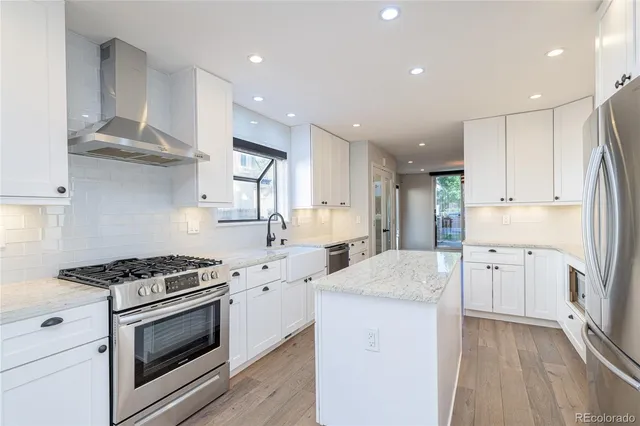 a kitchen with white cabinets and appliances