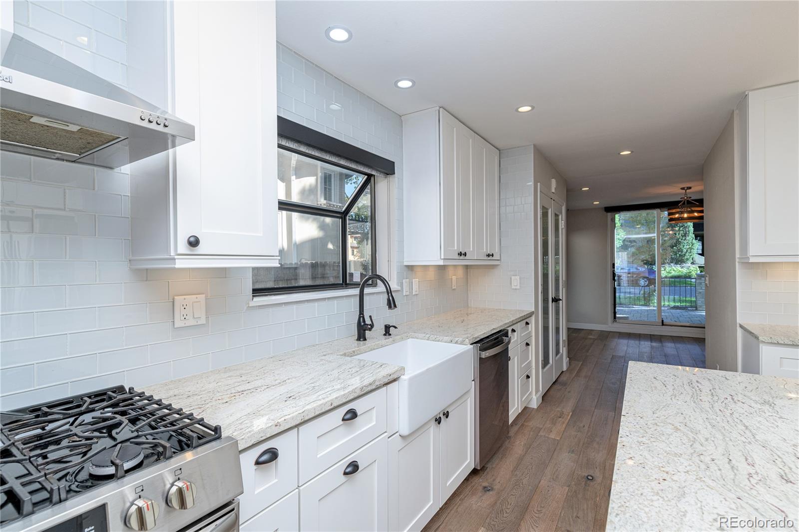 541 Monroe Street, Unit A Denver, CO 80206 - Photo 17 of 45 a kitchen with granite countertop a sink stove and cabinets