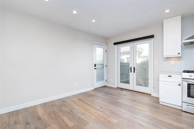 a view of a big room with wooden floor and windows