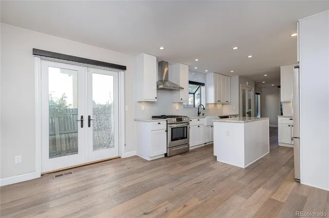a kitchen with white cabinets and appliances