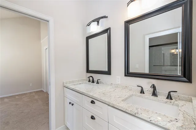 a bathroom with double sink and a mirror