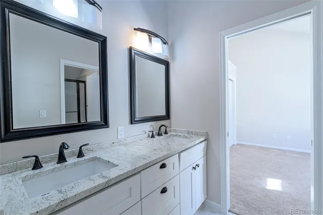 a bathroom with double sink and a mirror