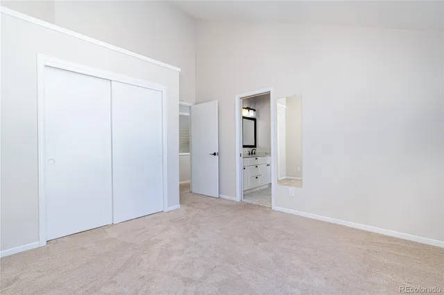 an empty room with closet and mirror