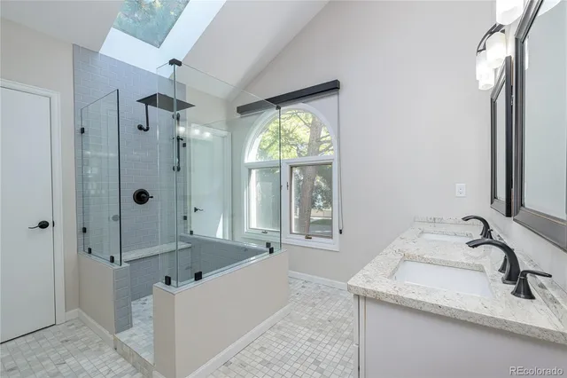 a bathroom with a granite countertop tub sink and mirror