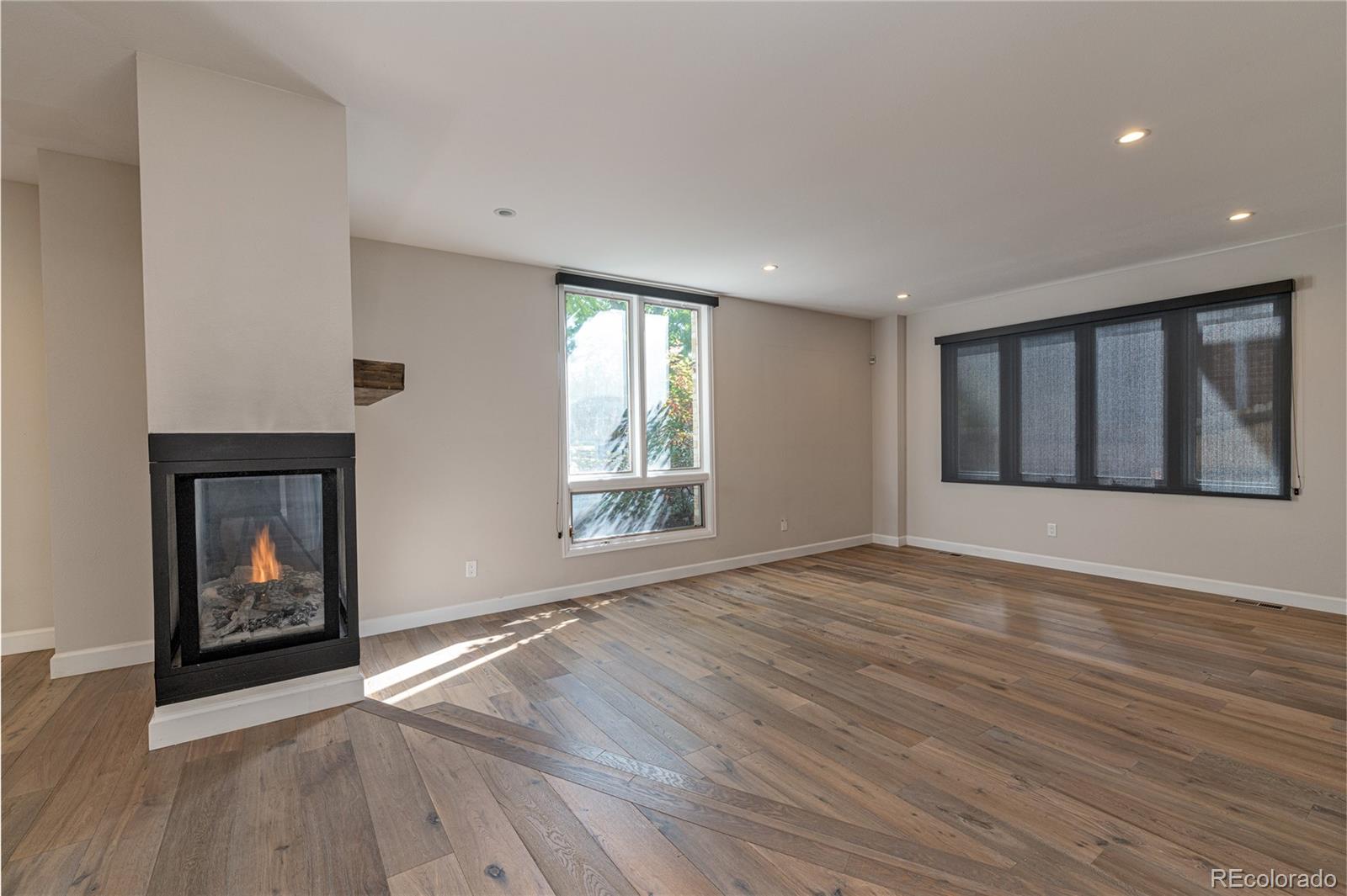 541 Monroe Street, Unit A Denver, CO 80206 - Photo 6 of 45 an empty room with wooden floor fireplace and windows