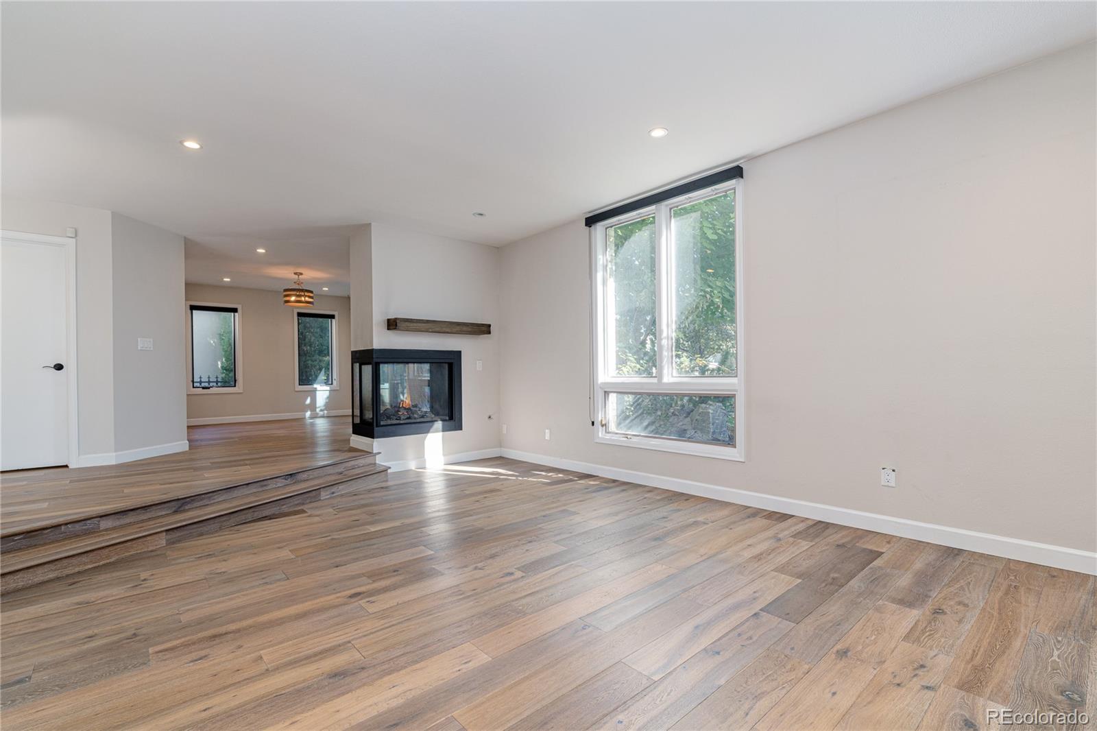 541 Monroe Street, Unit A Denver, CO 80206 - Photo 7 of 45 an empty room with wooden floor fireplace and windows