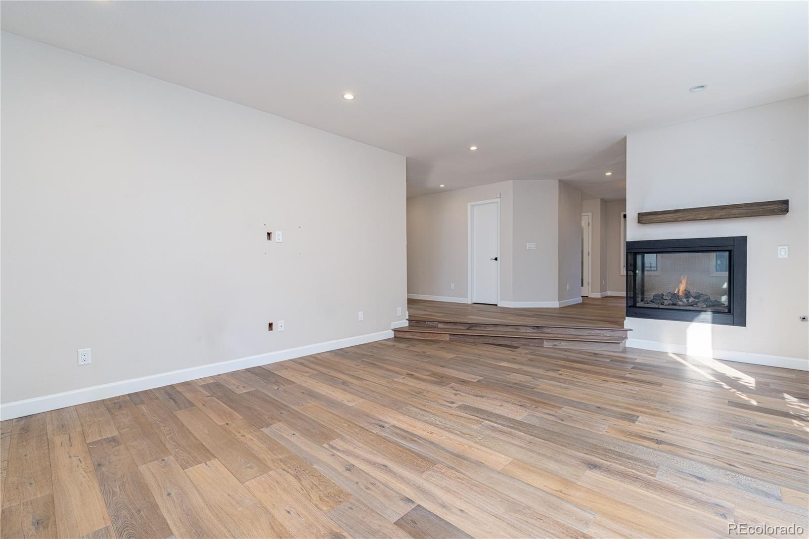 541 Monroe Street, Unit A Denver, CO 80206 - Photo 8 of 45 a view of empty room with wooden floor and fireplace