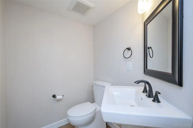 a bathroom with a sink and mirror with toilet