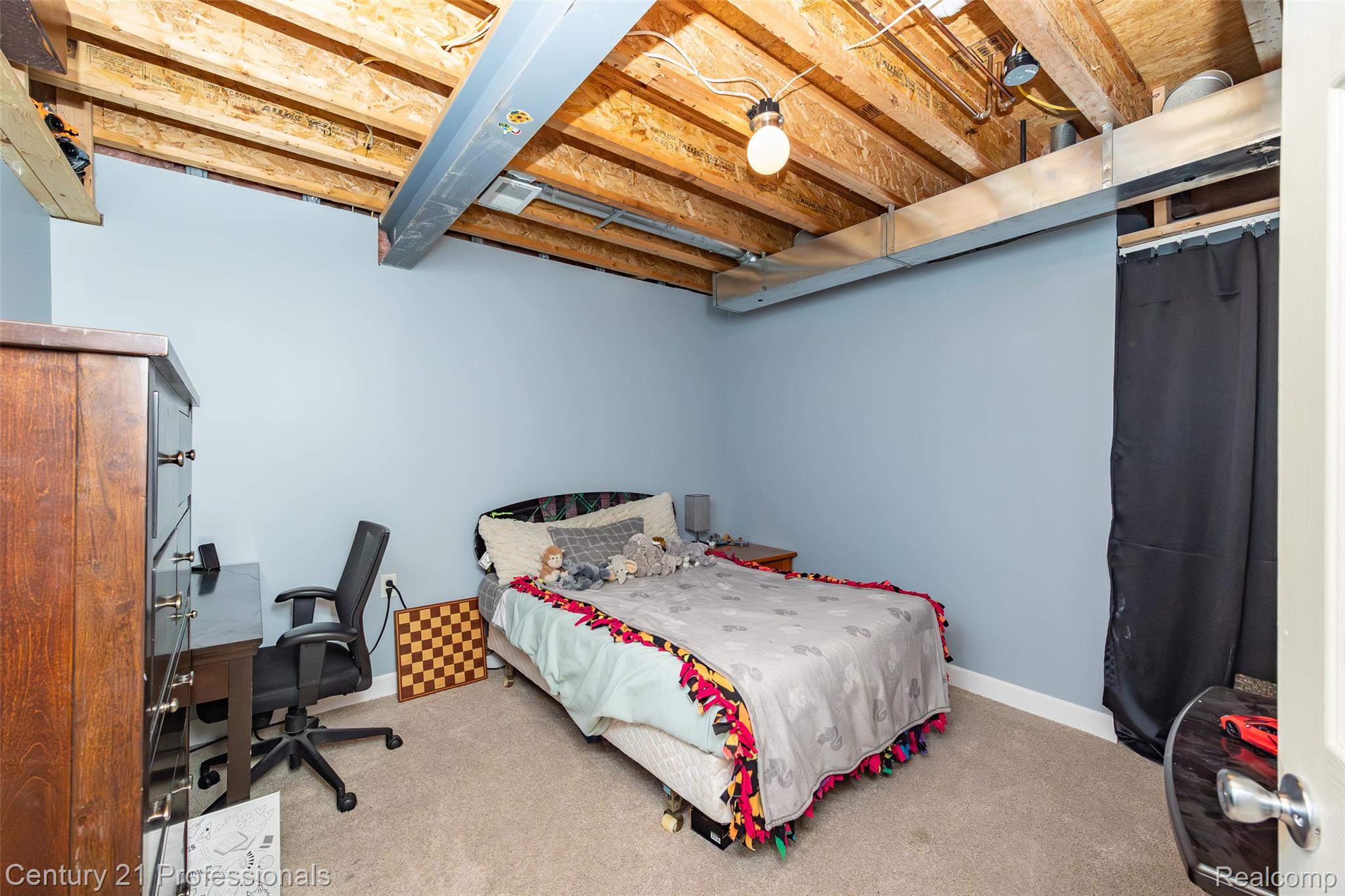 3251 Mann Road Clarkston, MI 48346 - Photo 32 of 40 Carpeted room with light blue walls and exposed ceiling joists