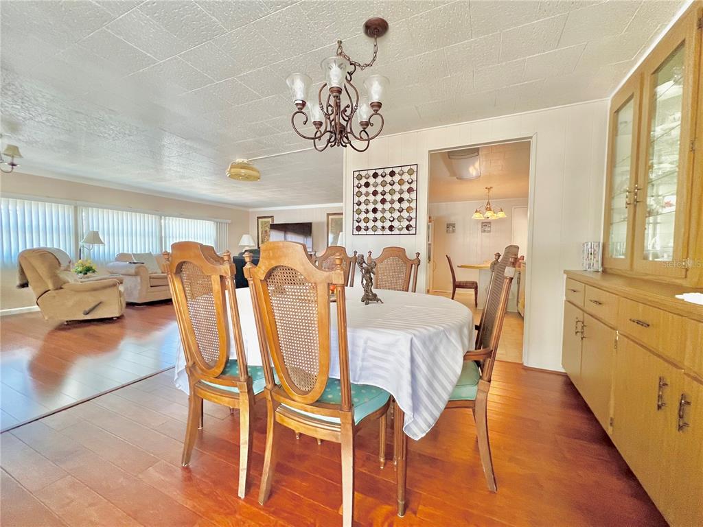 1100 South Belcher Road, Unit 719 Largo, FL 33771 - Photo 20 of 60 a dining room with wooden floor and chandelier