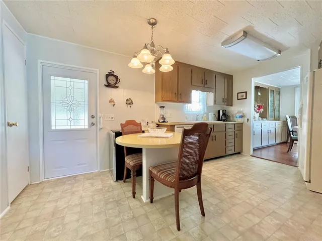 a kitchen with stainless steel appliances granite countertop a stove a refrigerator a oven a dining table and chairs with wooden floor