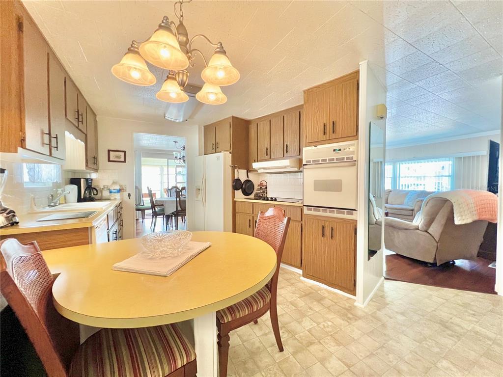 1100 South Belcher Road, Unit 719 Largo, FL 33771 - Photo 24 of 60 a kitchen with stainless steel appliances kitchen island granite countertop a refrigerator a stove a sink dishwasher and white countertops with wooden floor