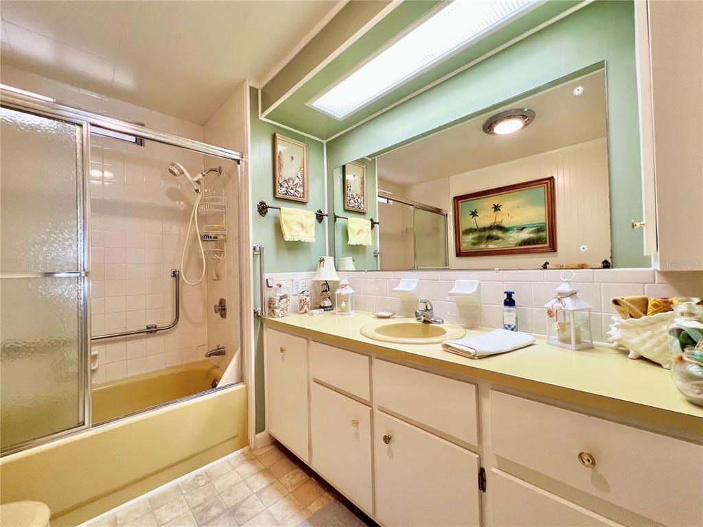 1100 South Belcher Road, Unit 719 Largo, FL 33771 - Photo 42 of 60 a bathroom with a granite countertop sink mirror bathtub and shower