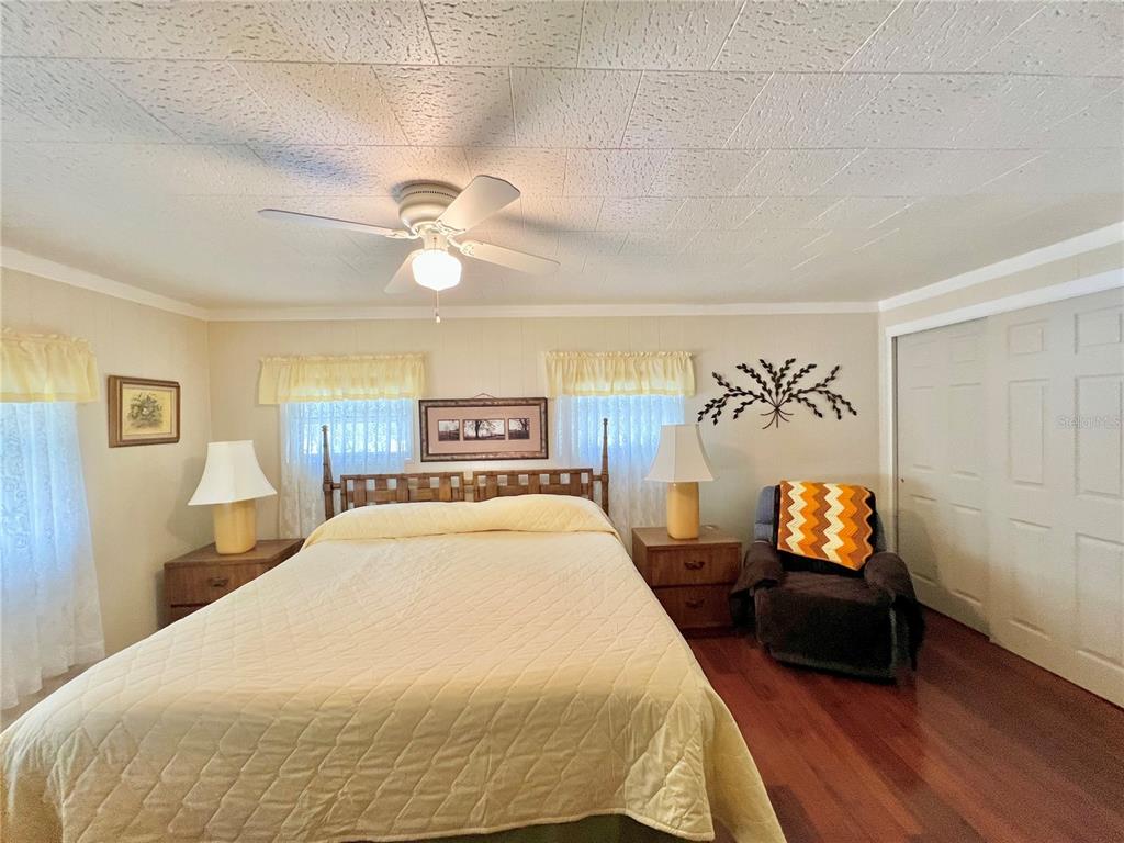 1100 South Belcher Road, Unit 719 Largo, FL 33771 - Photo 54 of 60 a spacious bedroom with a bed and a chandelier