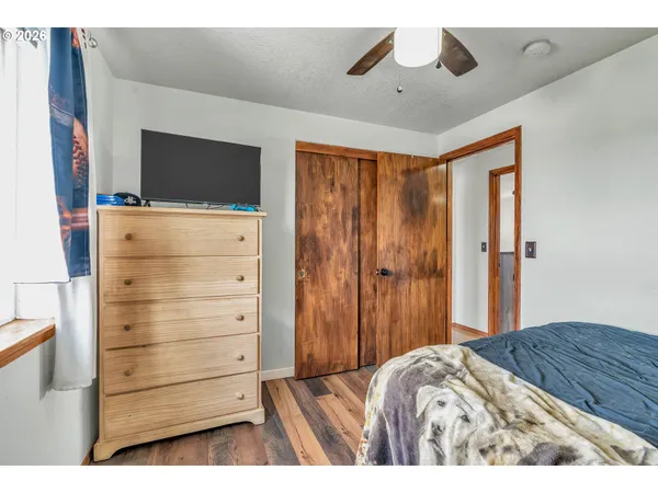 a bedroom with a bed window and a flat tv screen
