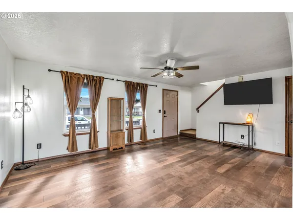 a view of an empty room with wooden floor