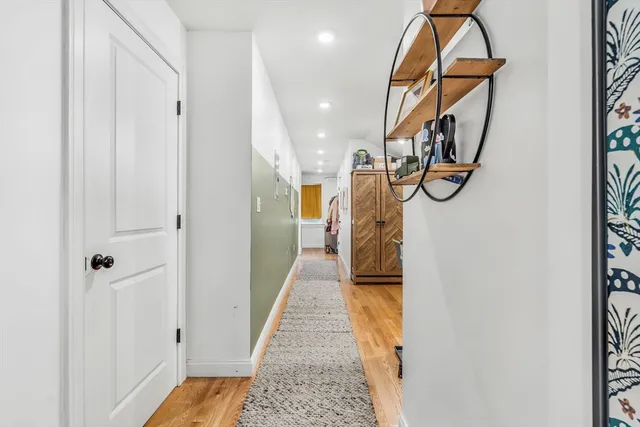 a view of a hallway with wooden floor and staircase