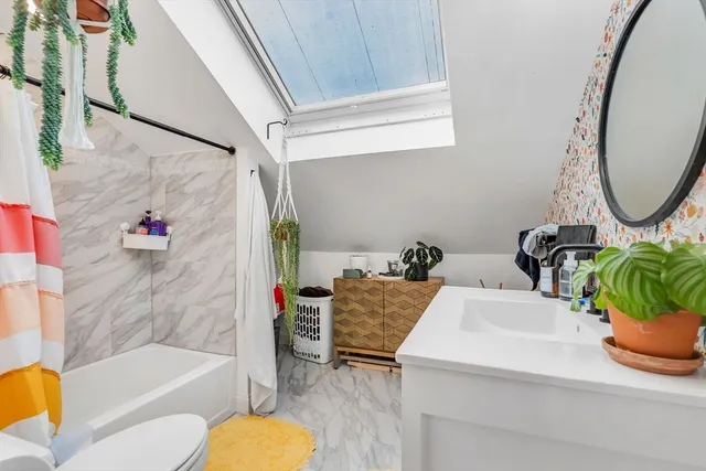 a bathroom with a tub sink and mirror