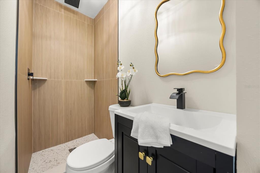 115 West Fillmore Avenue Orlando, FL 32809 - Photo 12 of 23 a bathroom with a sink a toilet and a mirror