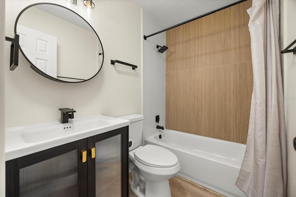 115 West Fillmore Avenue Orlando, FL 32809 - Photo 16 of 23 a bathroom with a sink a toilet and a mirror