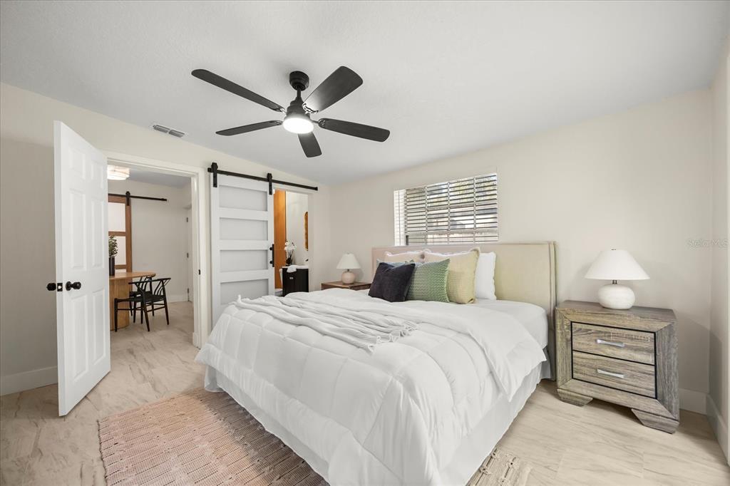 115 West Fillmore Avenue Orlando, FL 32809 - Photo 9 of 23 a bedroom with a bed and a chandelier