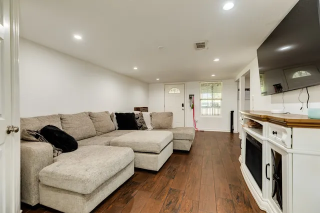 a living room with furniture and a wooden floor
