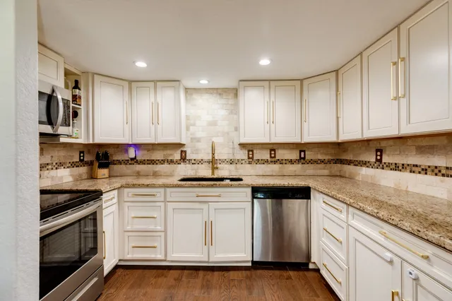 a kitchen with stainless steel appliances granite countertop a sink and cabinets