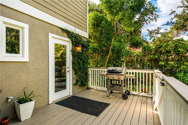 a balcony with wooden floor table and chairs