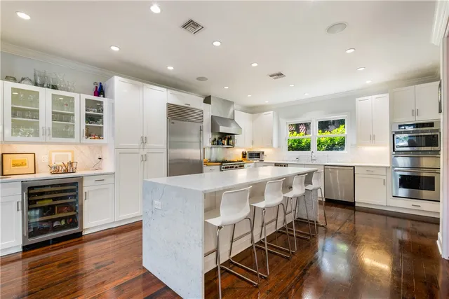 a kitchen with stainless steel appliances kitchen island granite countertop a stove and a refrigerator